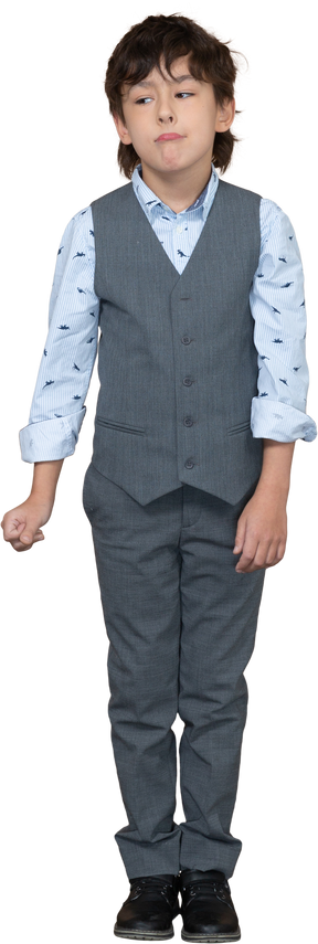 Front view of a boy in suit standing still and making faces