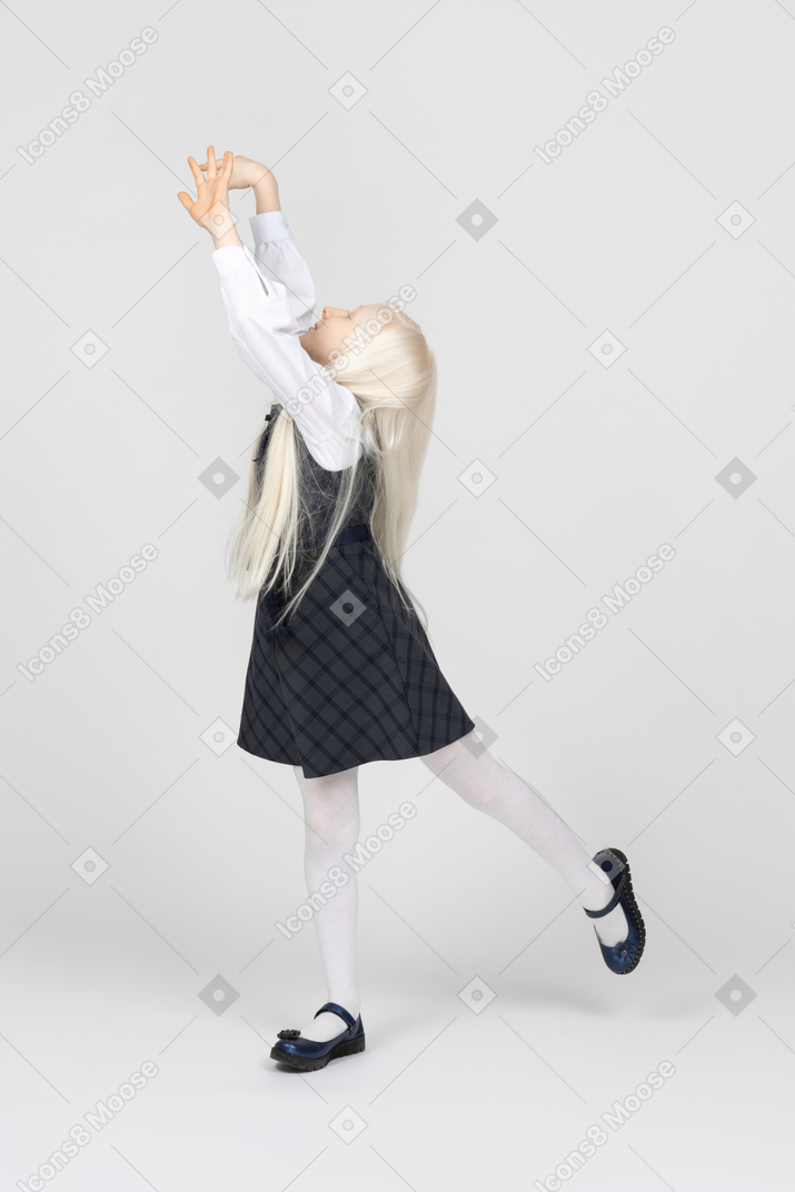 Schoolgirl with long hair doing a ballet pose