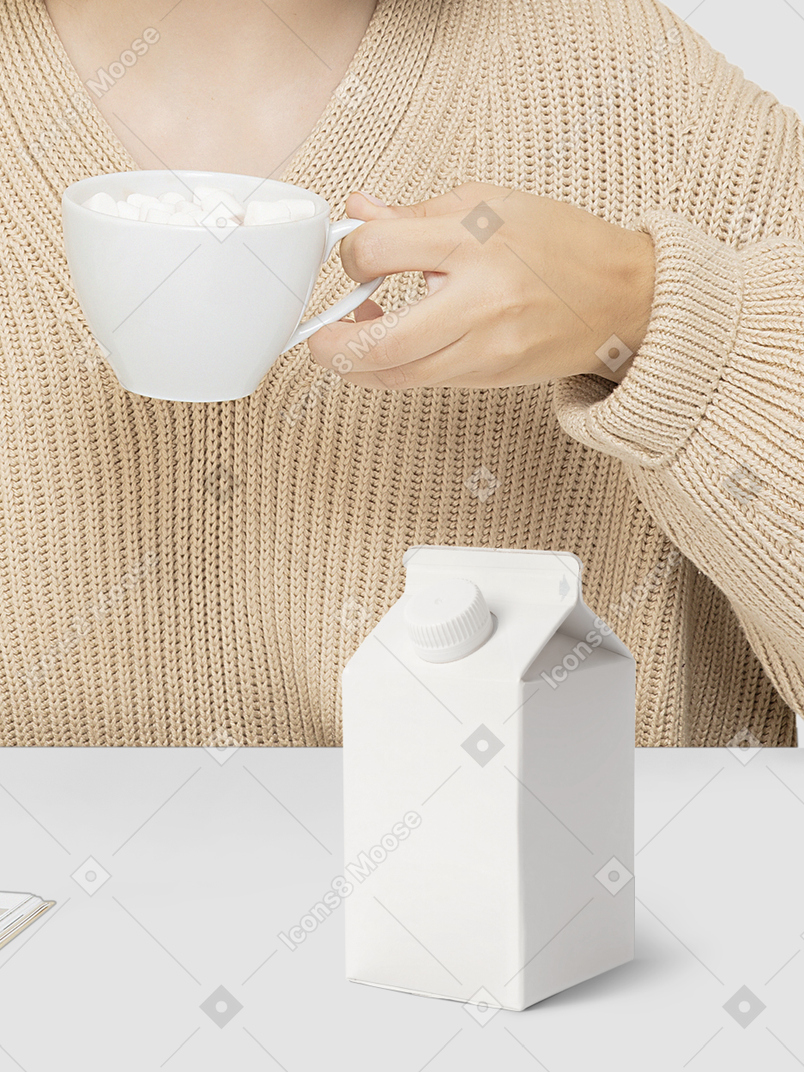 A woman holding a cup of coffee and a milk carton