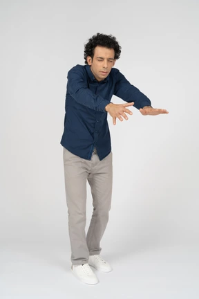 Front view of a man in casual clothes standing with outstretched arms
