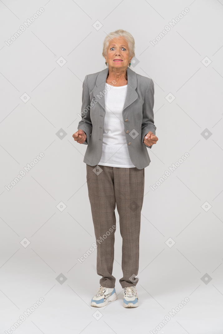 Scared old lady in grey jacket looking at camera