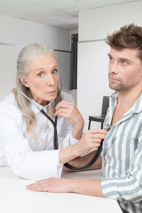 A doctor examining a patient's chest with a stethoscope