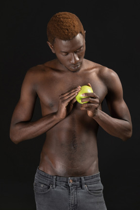 一个年轻的男性，照顾一个绿色苹果的特写