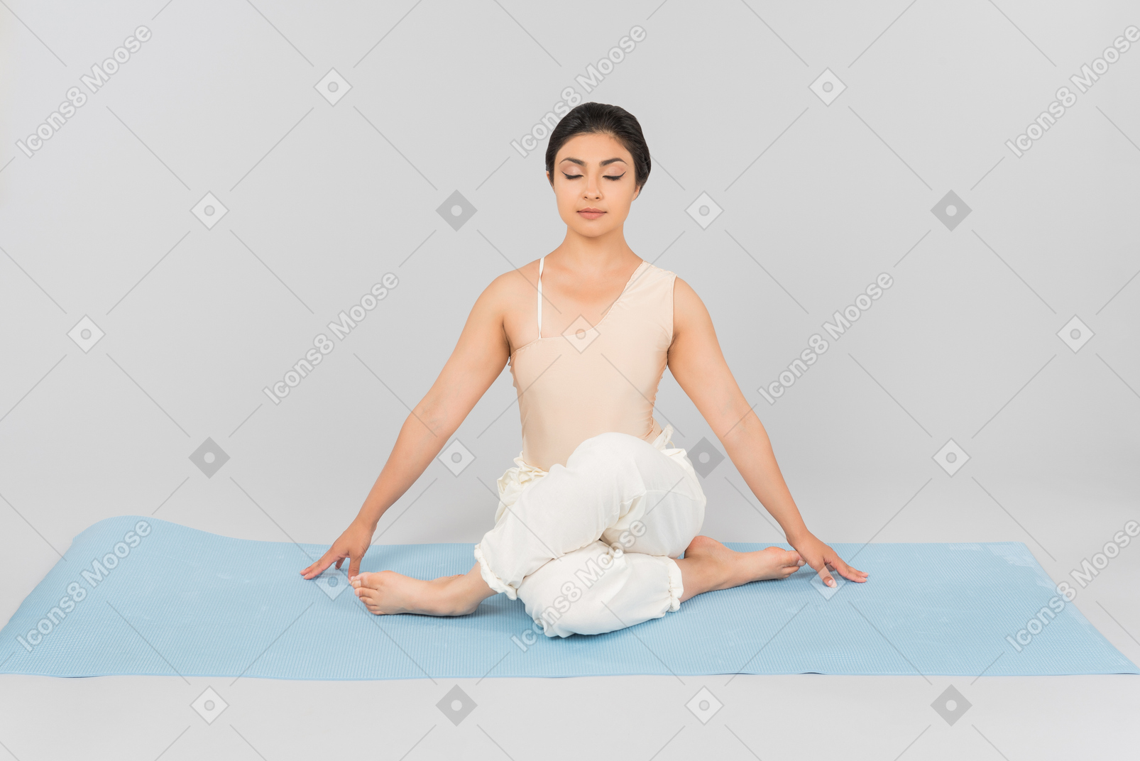 Junge indische frau sitzt auf yoga-matte mit gekreuzten beinen und geschlossenen augen