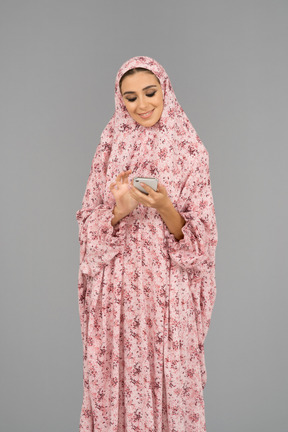 Веселая арабская женщина с мобильным телефоном