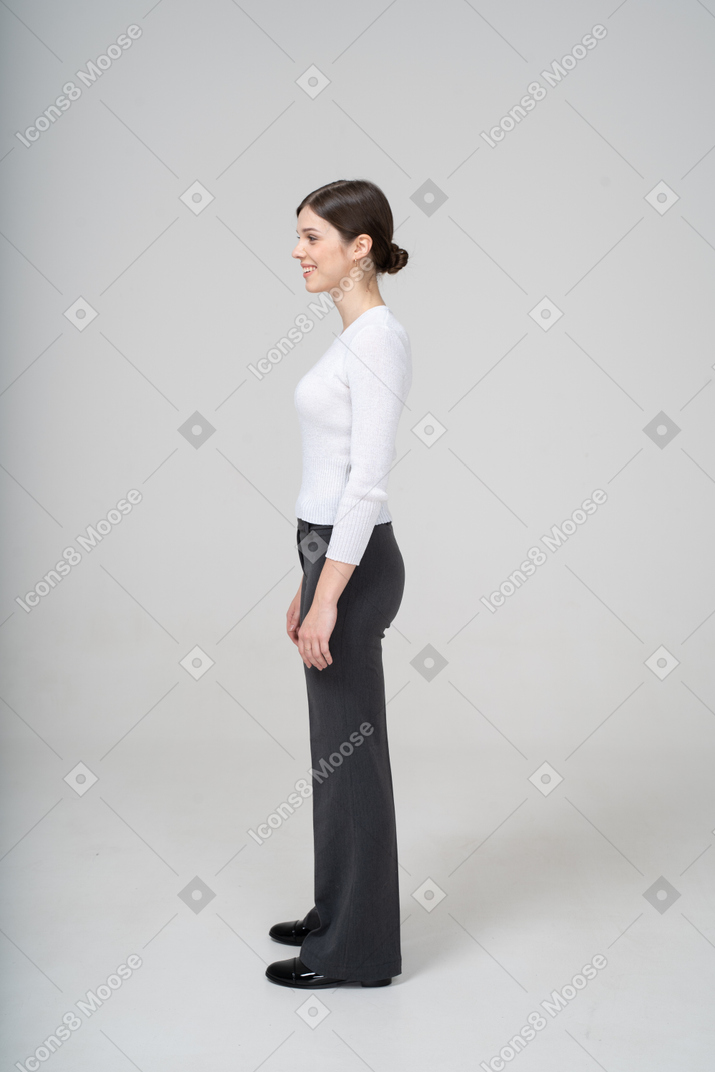 Side view of a smiling woman in business casual clothes looking away