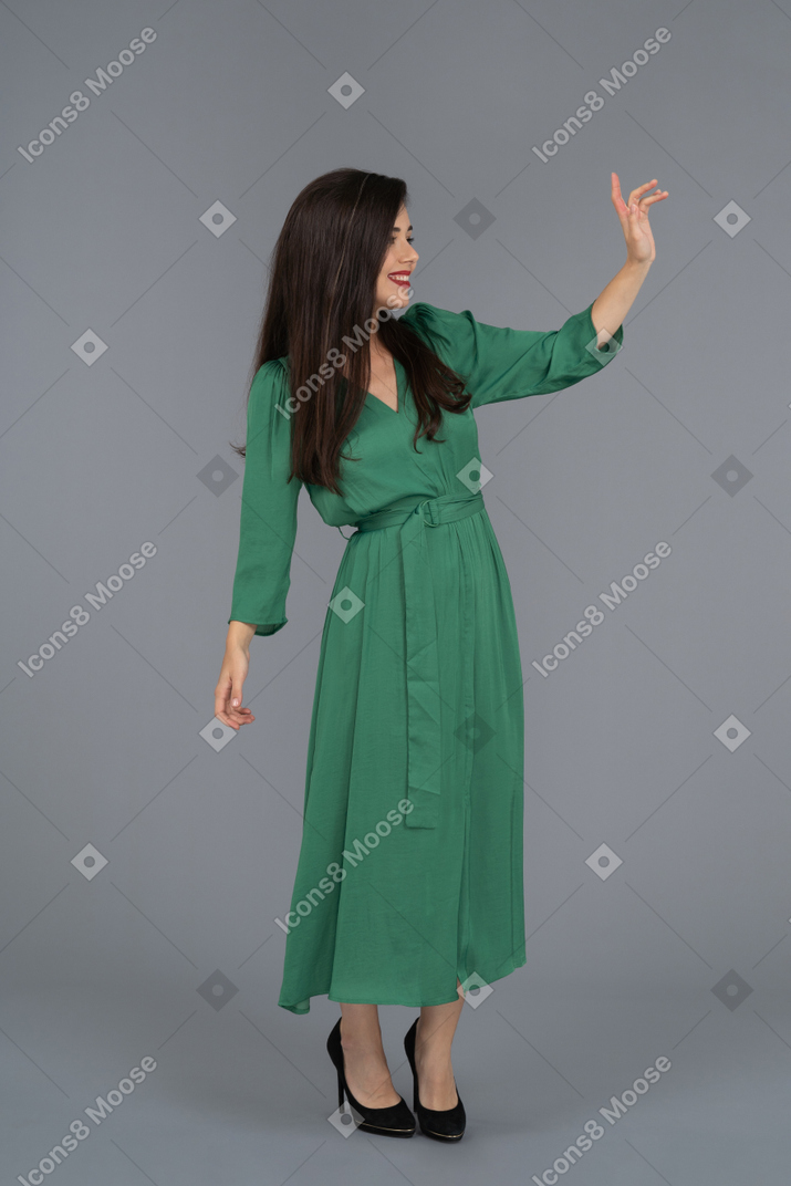 A young woman waving hand backwards to camera