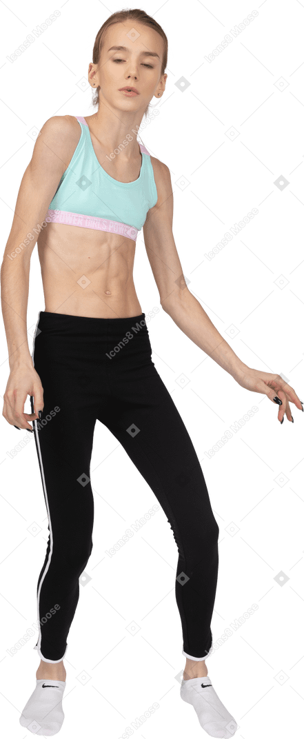 Front view of a teen girl in sportswear tilting shoulders