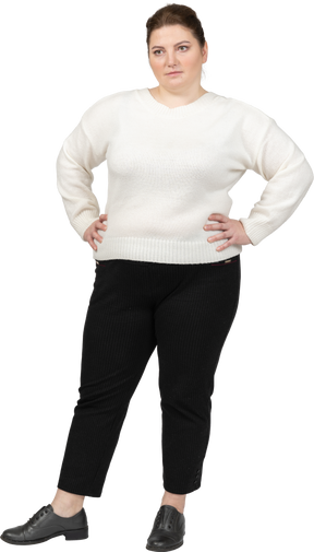 Plump woman in white sweater posing