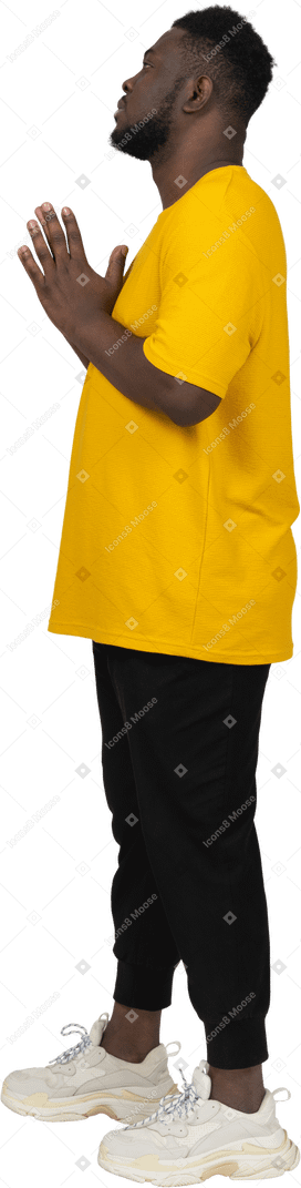 一个身穿黄色 t 恤、手牵手的黑皮肤年轻男子的侧视图