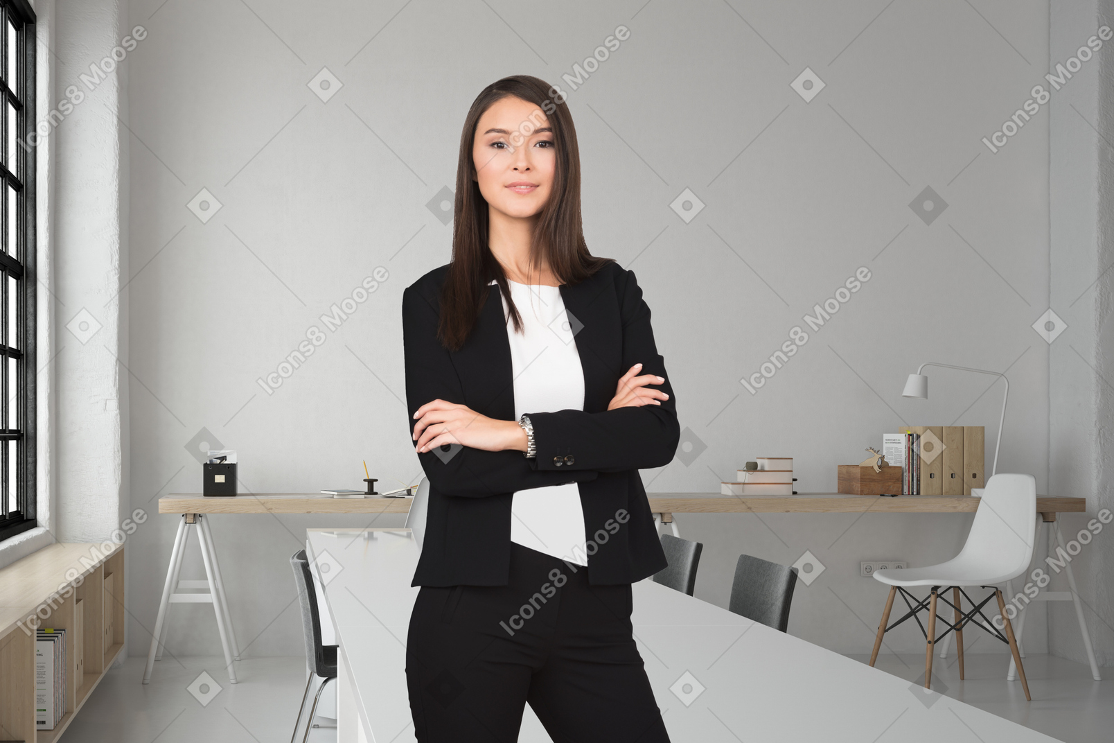 A business woman standing with her arms crossed in front of an empty office