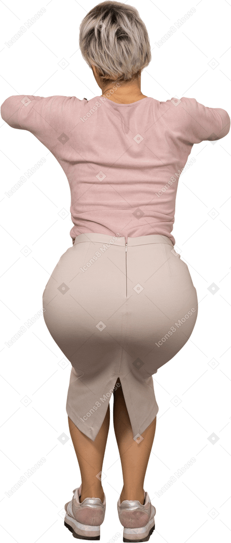 Rear view of a woman in casual clothes squatting