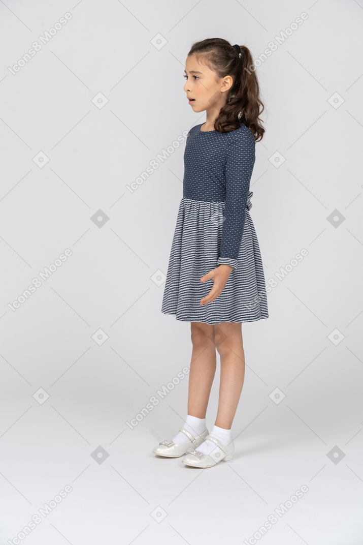 Vista de tres cuartos de una niña que parece desconcertada y ofendida