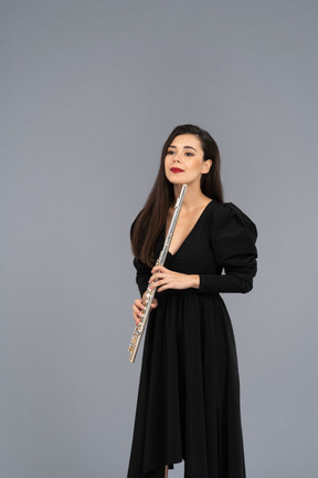 Front view of a young lady in black dress holding flute