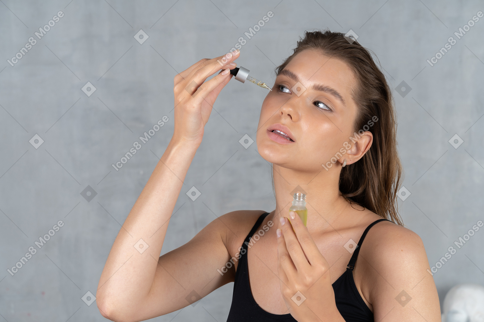 Close-up de uma jovem aplicando óleo facial
