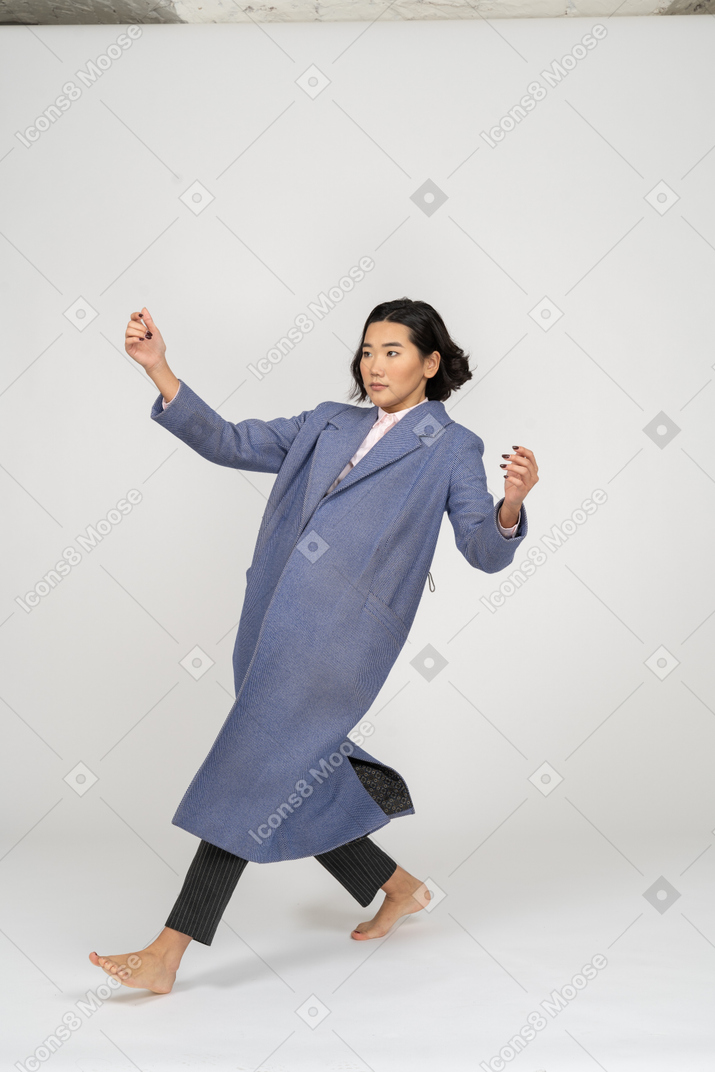 Woman in coat falling backwards