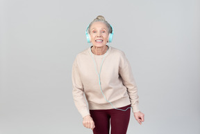 Old lady in listening music in headphones