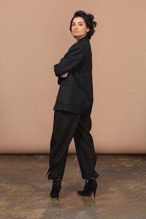 Full-length of a businesswoman in a black suit looking at camera while pouting