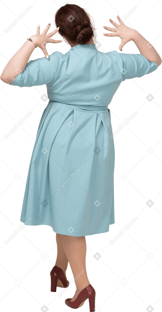 一个穿着蓝色裙子摆姿势的女人的后视图
