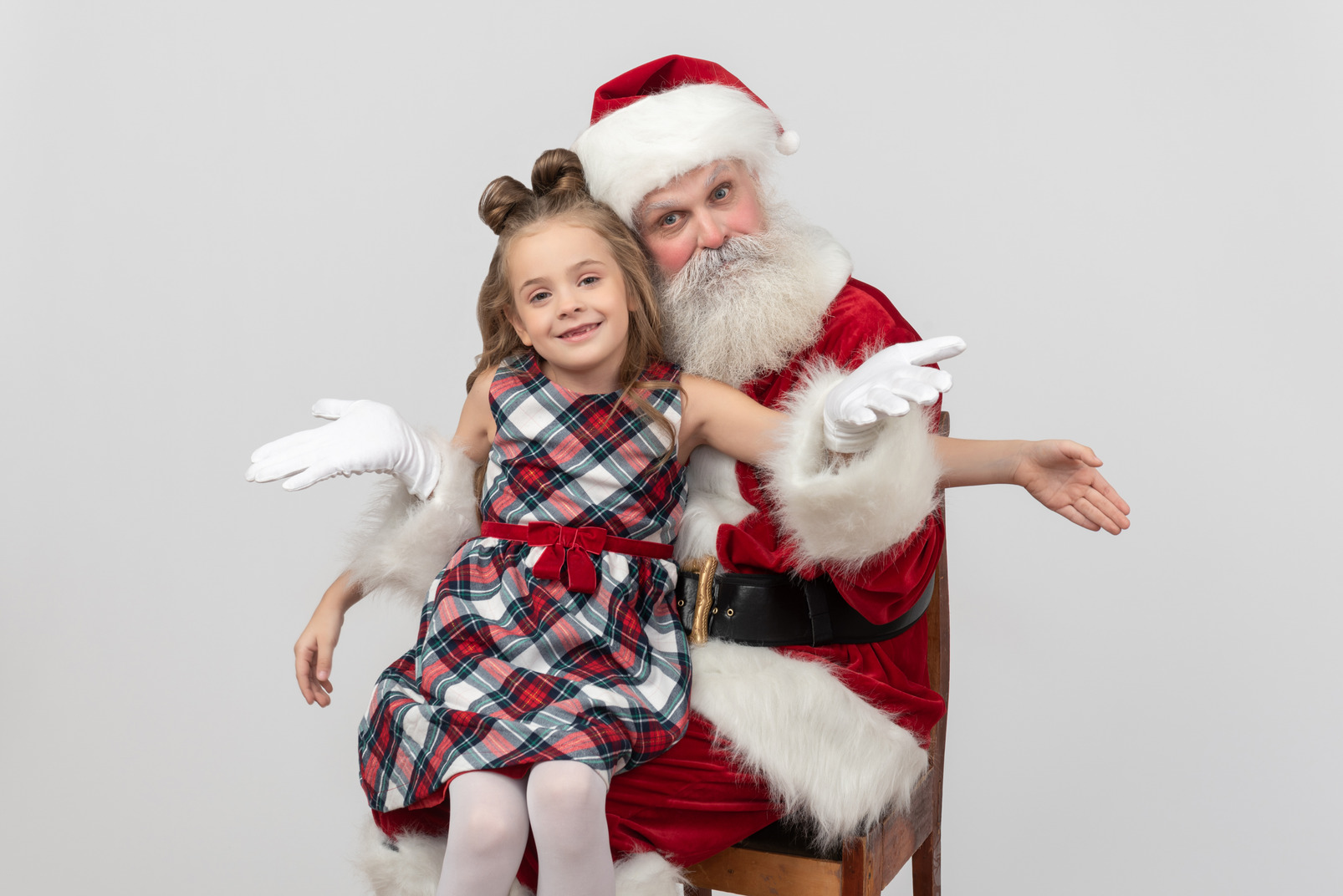 Little kid girl and santa sitting together