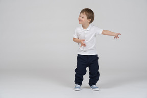 Vista frontal de un niño agitando las manos y sonriendo ampliamente