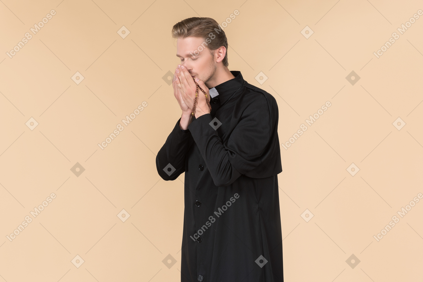 Catholic priest praying with eyes closed using prayer beads