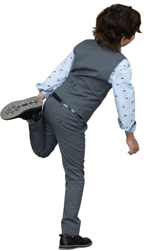 Vista posteriore di un ragazzo in abito grigio in piedi su una gamba
