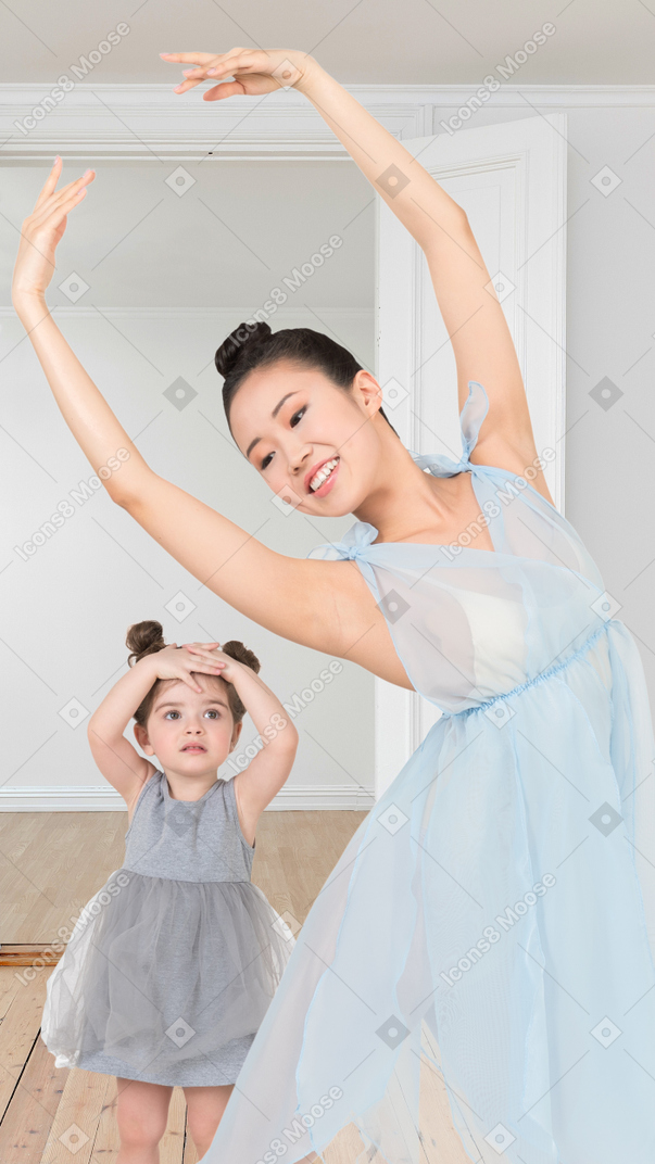A woman and a little girl dancing in blue dresses
