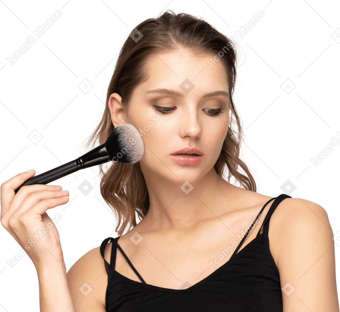 Vista frontal de uma jovem sensual segurando um pincel de maquiagem