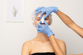 Close-up of doctor putting gauze on patient's nose