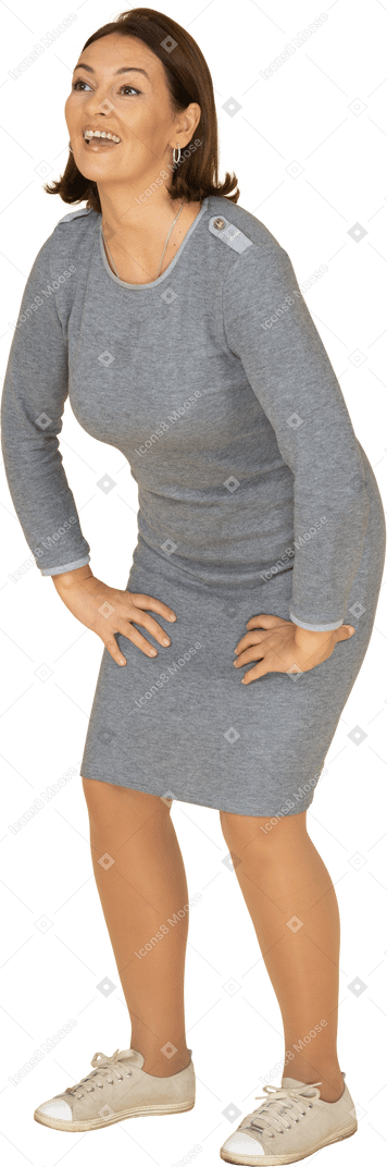 Mujer en vestido gris de pie en el perfil