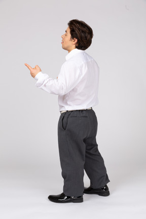 Side view of a young man with closed eyes pointing up