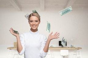 Woman standing in the office among flying banknotes