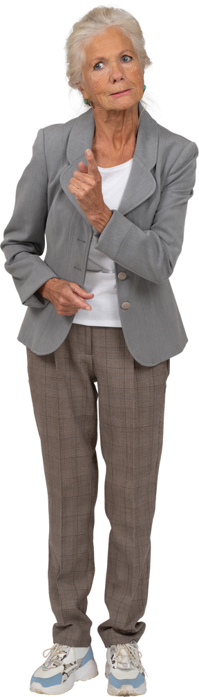 Front view of an angry old lady in suit showing warning gesture