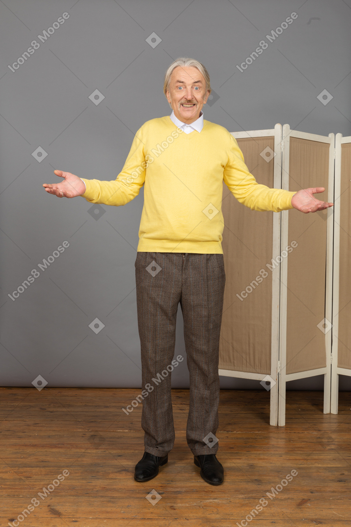 Vista frontale di un uomo anziano sorridente vicino allo schermo alzando le mani