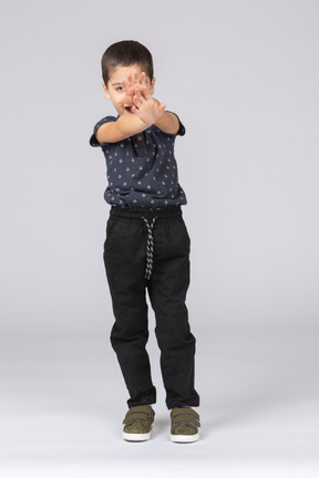 Vista frontal de un niño feliz de pie con los brazos extendidos