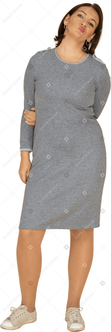 Front view of a woman in grey dress making faces