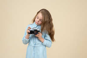 Bambina carina che tiene una macchina fotografica