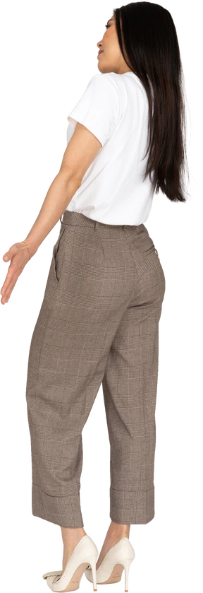 Three-quarter back view of a young lady in breeches and t-shirt outspreading her hands