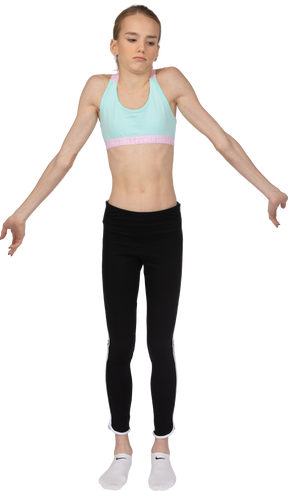 Front view of a puzzled teen girl in sportswear outspreading hands