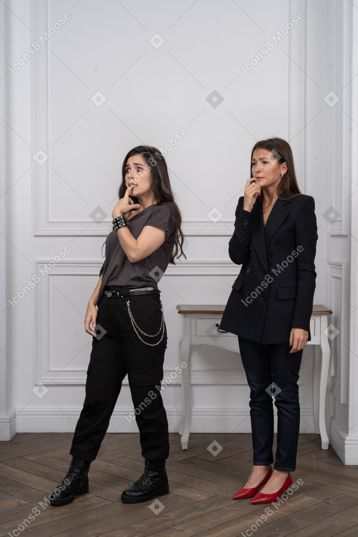 Two women biting nails