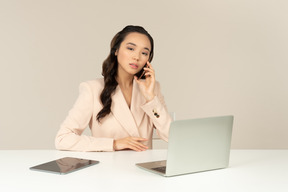 Employé de bureau femme asiatique impliqué dans une conversation téléphonique