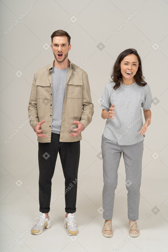 Vista frontal de una pareja joven enojada y gritando