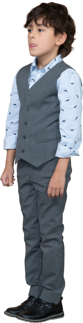 Front view of a boy in suit showing tongue