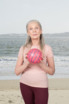 A woman holding a ball on a beach