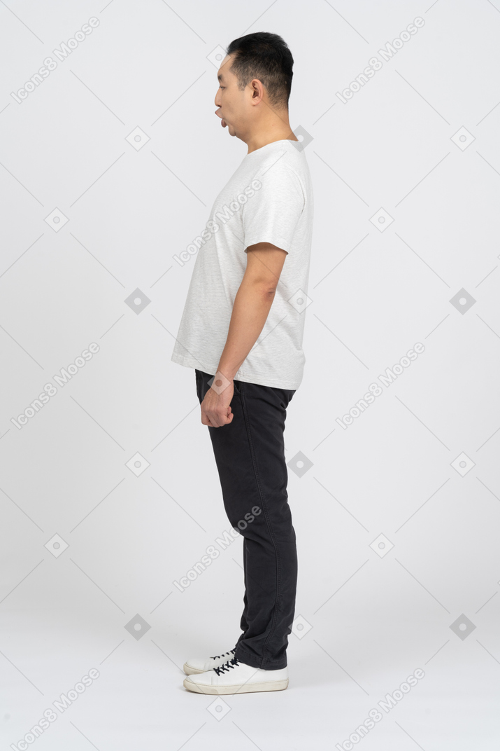 Side view of a man in casual clothes staring at something