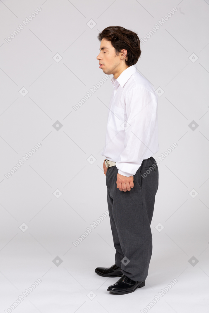 Vista lateral de um trabalhador de escritório masculino em pé com os olhos fechados