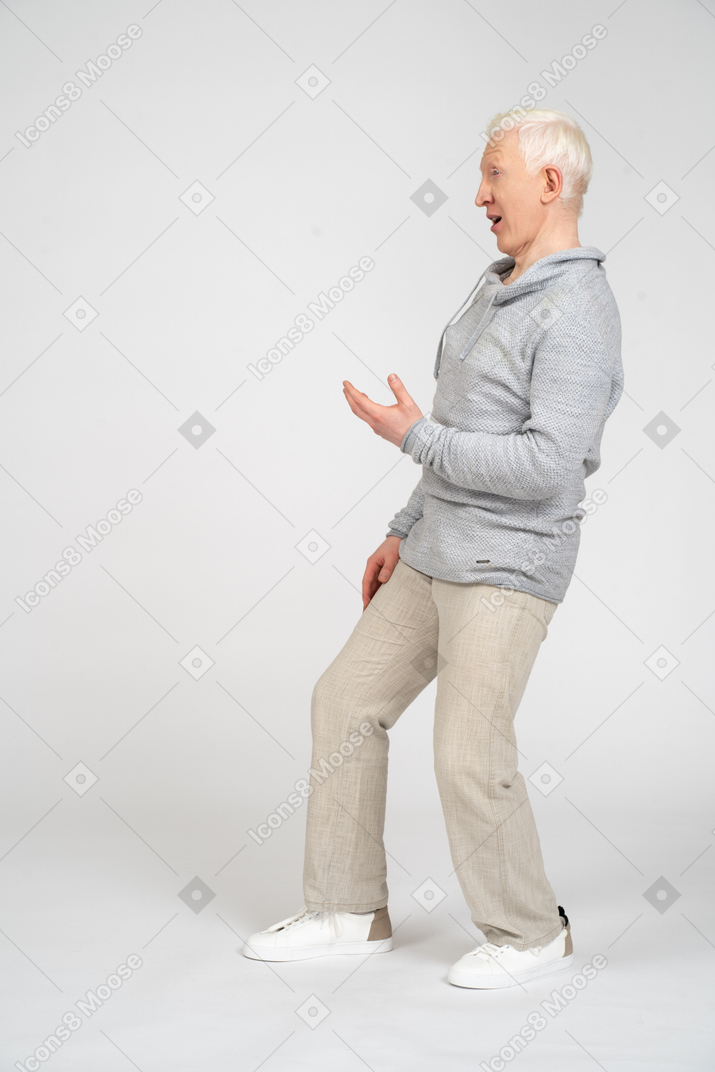 一个男人站着弯曲膝盖和举起手的侧视图