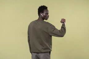 Young black man wearing casual clothes, with airpods and smartwatch on in the process of his workout