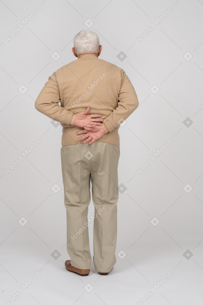 Rückansicht eines alten mannes in freizeitkleidung, der unter rückenschmerzen leidet